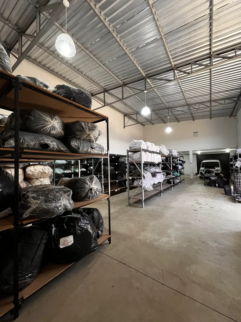 Prateleiras do estoque da FTM Wear com peças embaladas